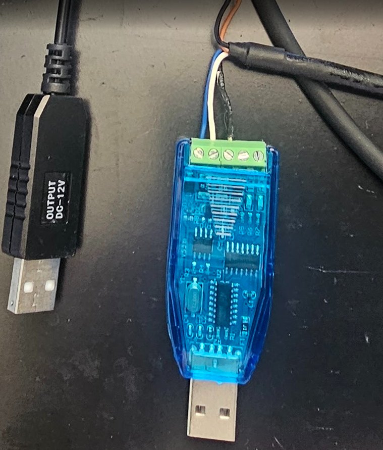 USB-RS485 converter with the AK330 cable's blue, white and black wires in its terminals, next to the 12 V USB cable that powers the antenna